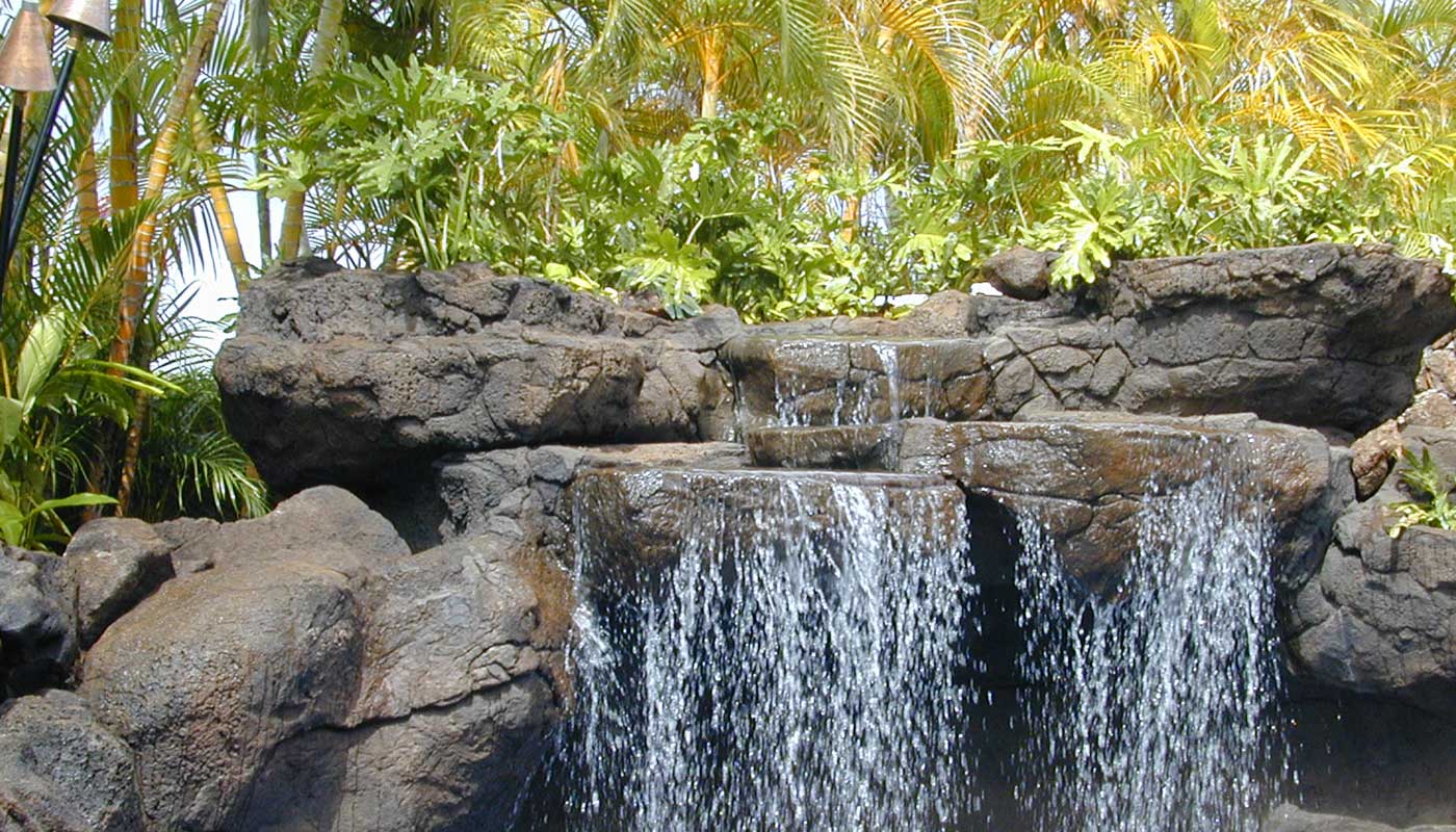 photo: custom water feature, a medium-size waterfall of realistic faux stone and landscaping plants