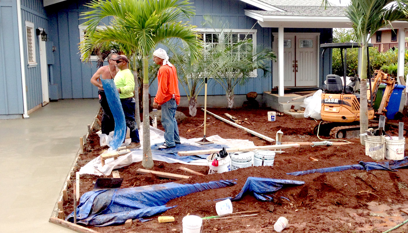 Photo: landscaping crew works around fresh wet concrete flatwork