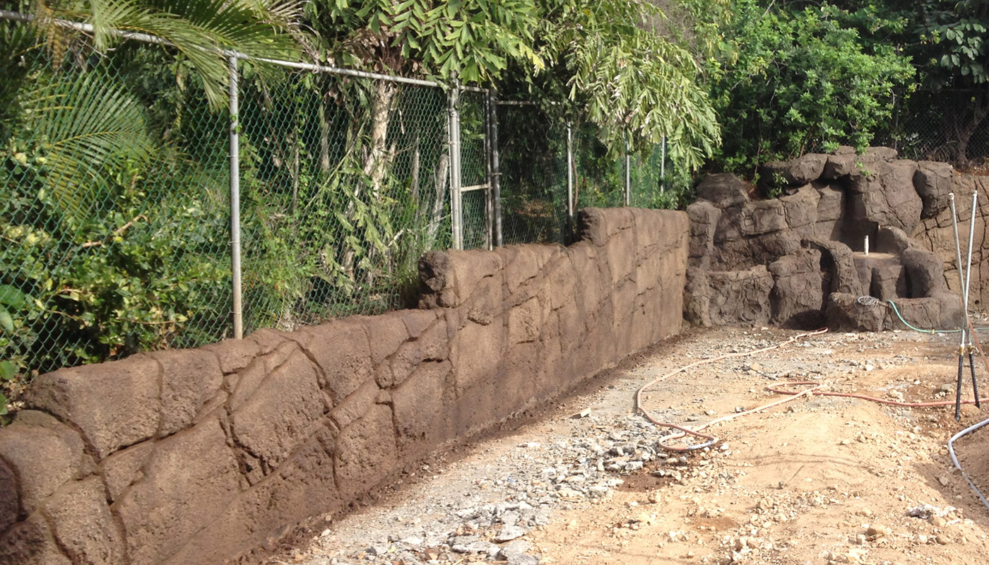 Slideshow: realistic faux stone wall on property boundary.