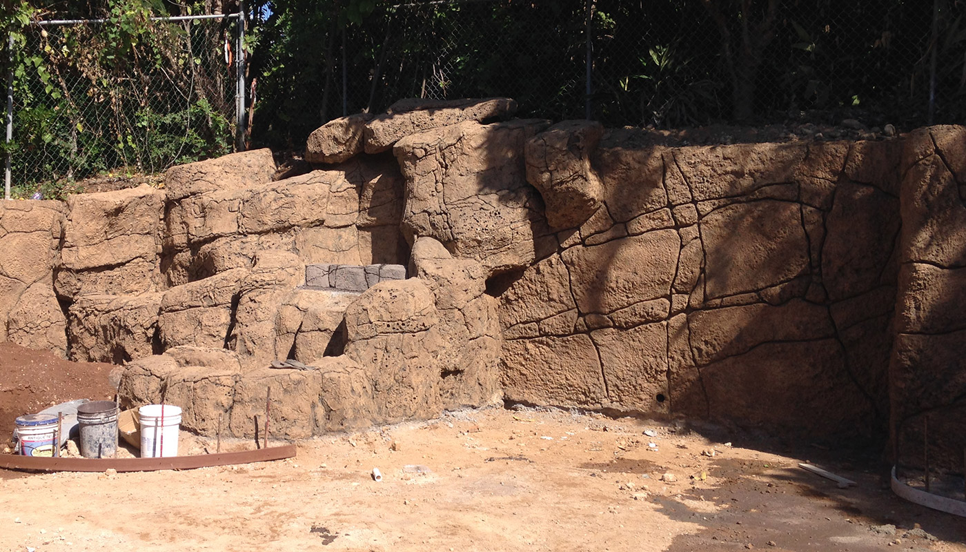 Slideshow: realistic faux stone wall on property boundary.