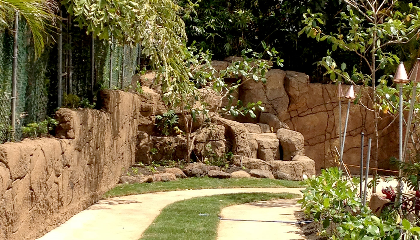 Slideshow: realistic faux stone wall on property boundary.